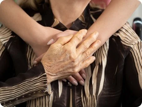 Cannabis in der Geriatrie und Palliativmedizin: Potenziale und Anwendungsmöglichkeiten Junge Person legt tröstend die Arme um die Schultern einer älteren Person