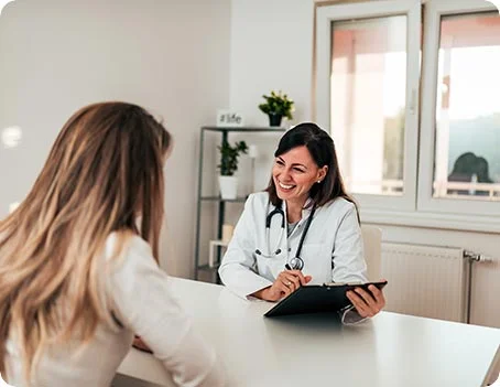 Ärztin führt Beratungsgespräch mit Patientin im Behandlungszimmer