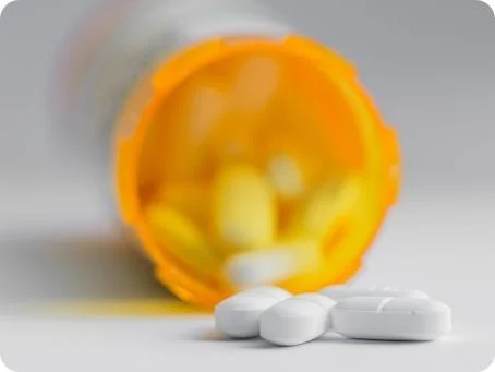 Tabletten, die vor einer gelben Verpackung liegen